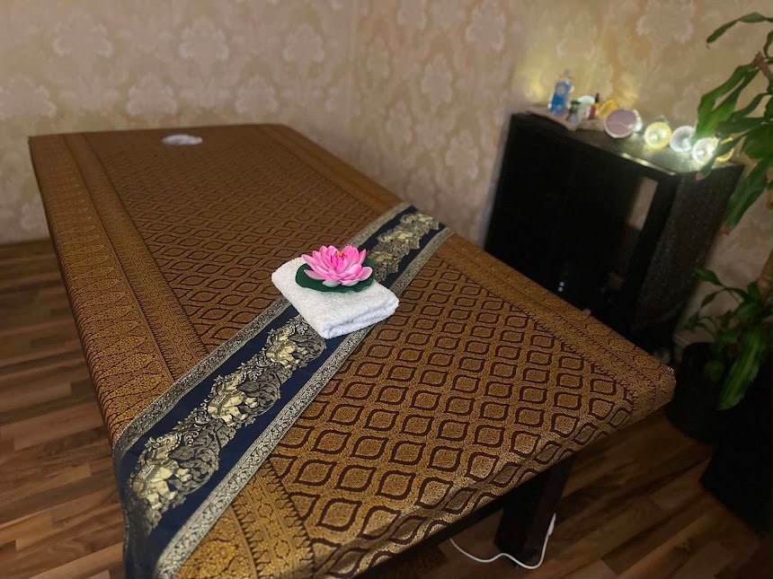 Massageliege mit Thai-Stoff und Lotusblüte